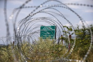 A warning sign is pictured behind a wire barricade erected by Russian and Ossetian troops along Georgia's de-facto border with its breakaway region of South Ossetia in the village of Khurvaleti, Georgia, July 14, 2015. Georgia accused Russia on Monday of violating its sovereignty by placing border markers on the edge of the South Ossetia region, leaving part of an international oil pipeline in territory under Russian control. REUTERS/David Mdzinarishvili - RTX1K9UA